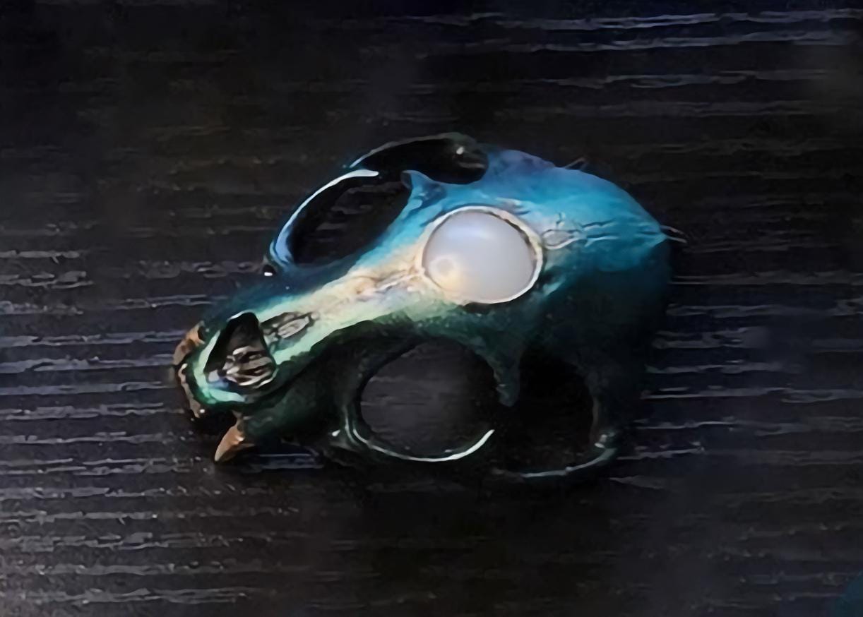 Cat skull hair pin (Small), Verdant paint scheme, pictured on a tabletop