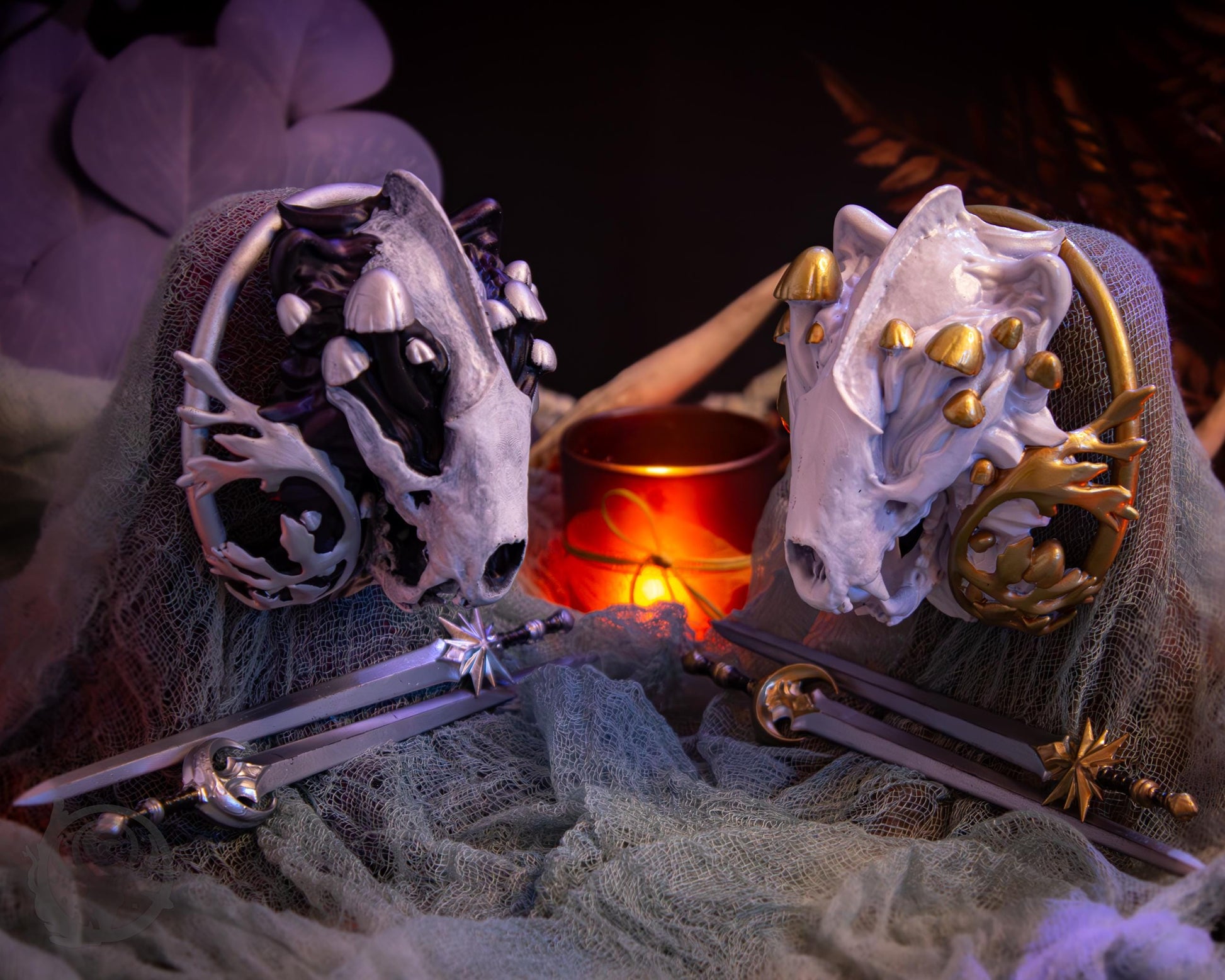 Two resin hair bun covers set up on stands, with their resin sword pins. The bun covers are badgers with gilded mushooms and mugwort leaves.