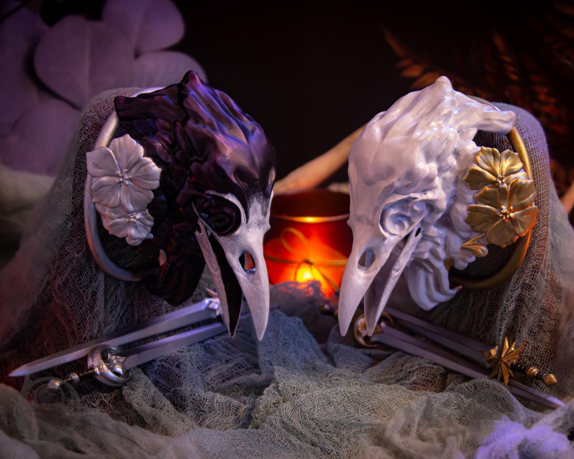 Two resin hair bun covers set up on stands, with their resin sword pins. The bun covers are ravens with gilded geraniums.