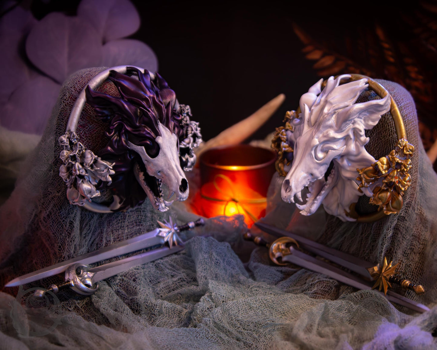 Two resin hair bun covers set up on stands, with their resin sword pins. The bun covers are wolves with gilded wolfsbane.